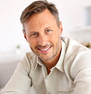 man in tan shirt smiling