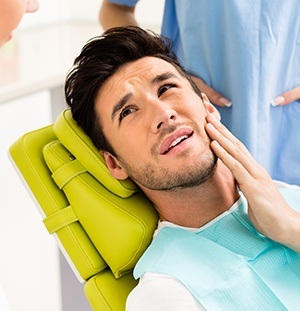 handsome man holding jaw in pain