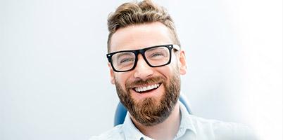 man with thick brim glasses smiling
