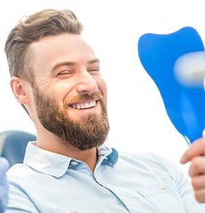 man smiling in blue mirror