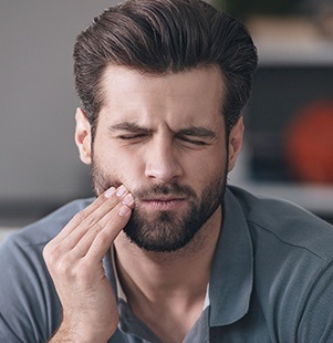 man holding jaw in pain