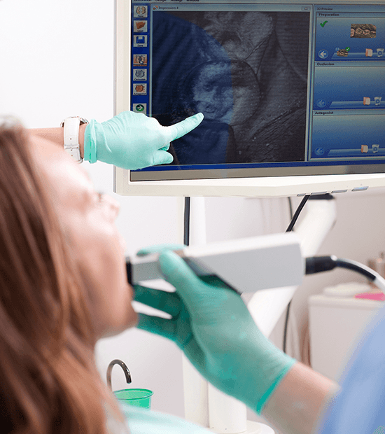 dentist pointing to cerec machine