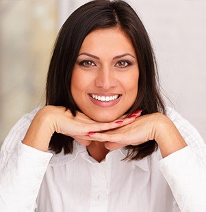 woman smiling with head on hands