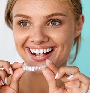 woman holding invisalign