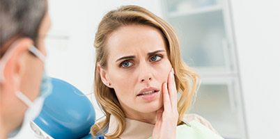 woman upset holding jaw