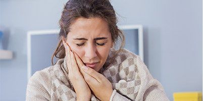 woman holding jaw with both hands